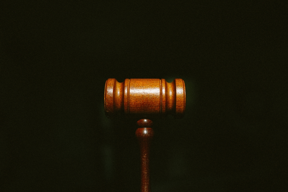 What Can Compensation Cover in a Personal Injury Case? - A wooden gavel centered on a dark background with grain.