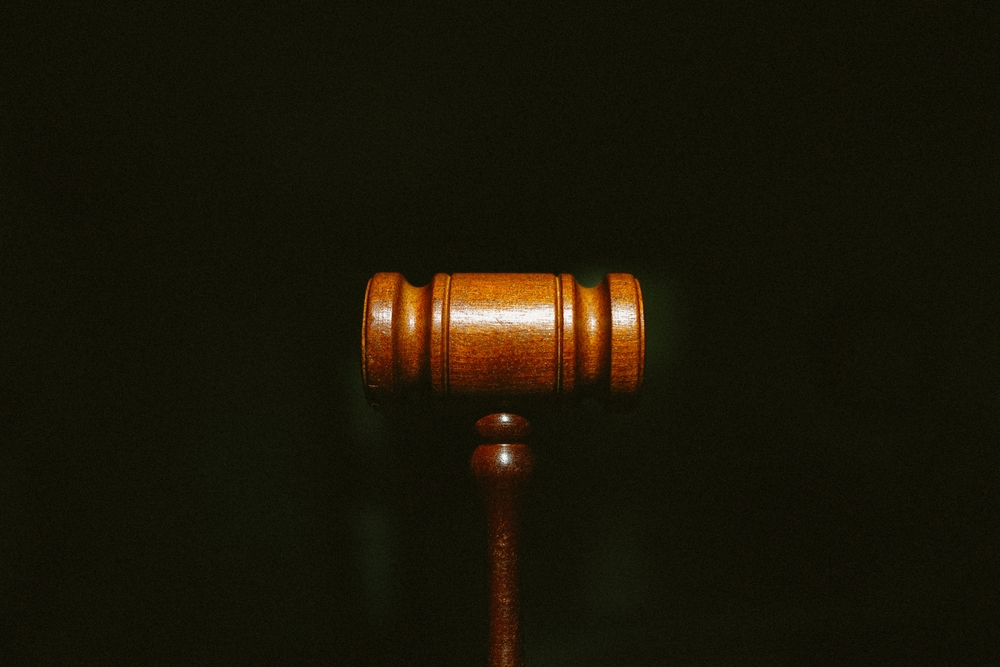 Why You Should File a Damage Claim Against The Nightclub and Not The Assailant - A wooden gavel centered on a dark background with grain.